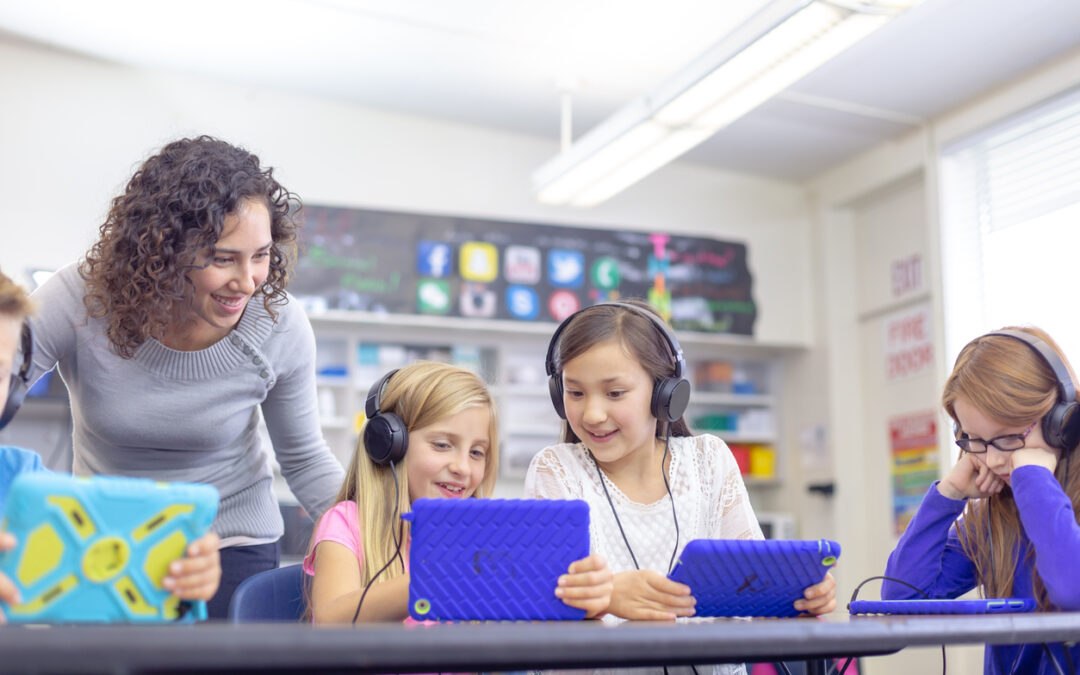 Young students learning lifelong digital literacy on tablets in classroom