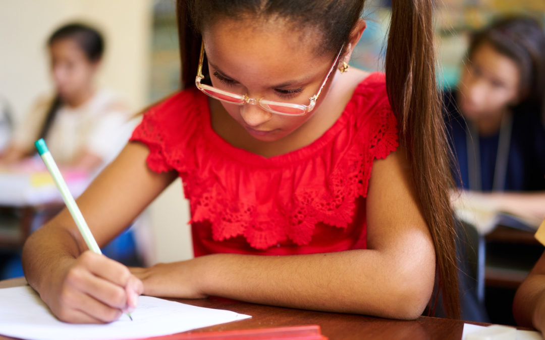 Young female student concentrating on computational thinking at classroom desk