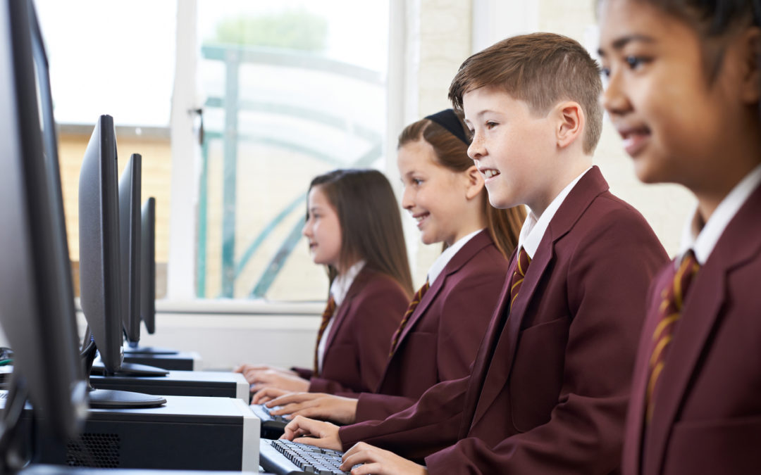 Uniformed students practicing digital literacy in a computer lab