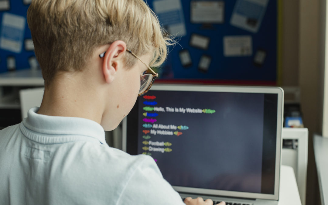 Male student being taught how to code on computer
